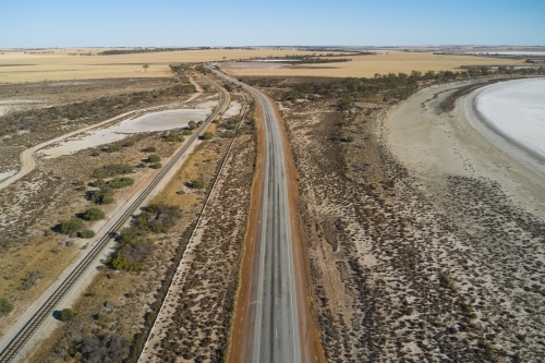 Country road through dry salt lakes - Australian Stock Image