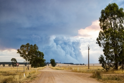 Country road with bushfire smoke in the distance - Australian Stock Image