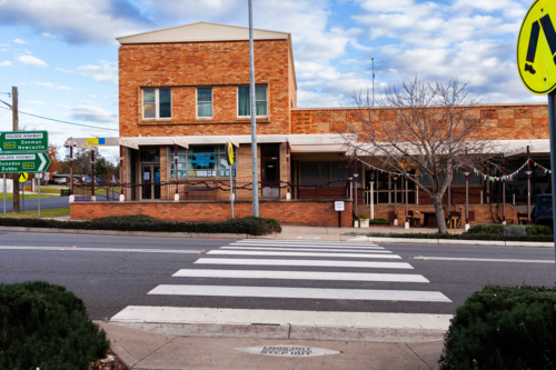 Country town of Merriwa looking across pedestrian crossing in street to brick building - Australian Stock Image