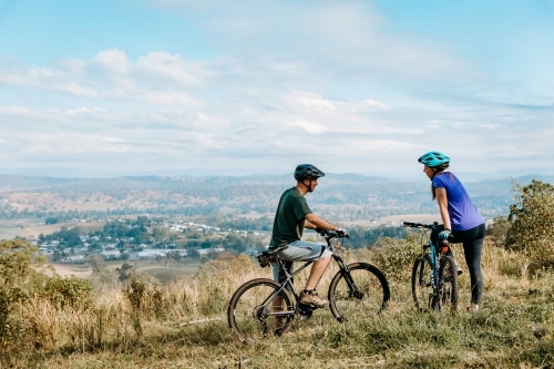 Couple at top of mountain on mountain bikes