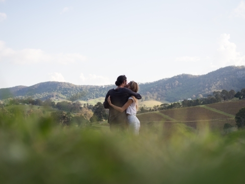 Couple cuddling whilst enjoying the view in Hunter Valley