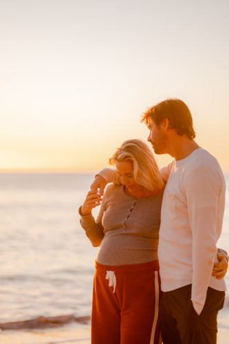 Couple enjoying sunrise at Manly Beach during maternity - Australian Stock Image
