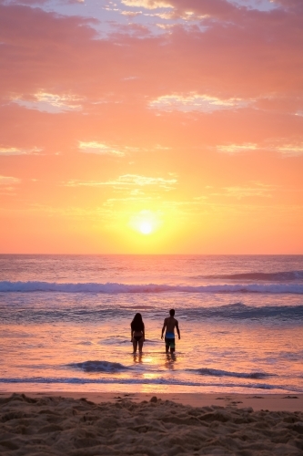 Couple in the water at sunrise