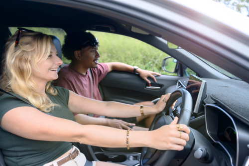 Couple on a road trip, woman driving the car - Australian Stock Image
