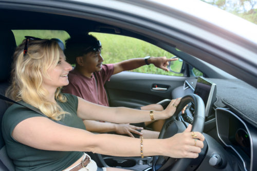 Couple on a road trip, woman driving the car - Australian Stock Image