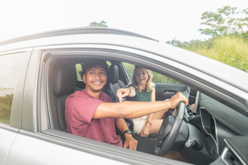 Couple sitting in their car looking outside their window - Australian Stock Image