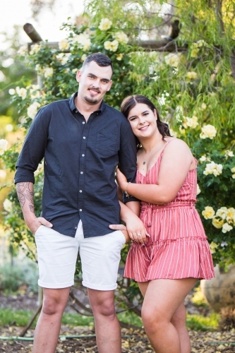 Couple standing together woman leaning on man smiling - Australian Stock Image