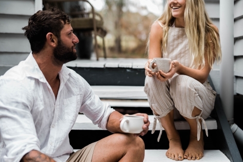 Couple talking on the steps of their front verandah - Australian Stock Image