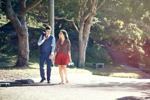Couple walking in the park in office clothing - Australian Stock Image