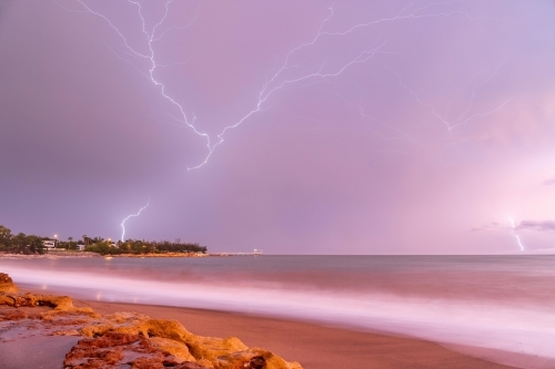 Crawler lightning over Nightcliff Jetty at sunrise with pink sky - Australian Stock Image