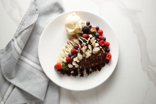 Cream cheese mixed berries crepe served in a white plate topped with sliced almonds. - Australian Stock Image