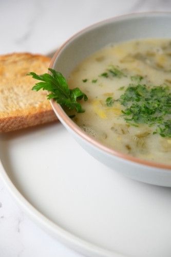 Cream of mushroom soup with a slice of toasted bread. - Australian Stock Image