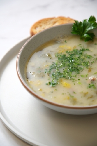 Cream of mushroom soup with a slice of toasted bread. - Australian Stock Image