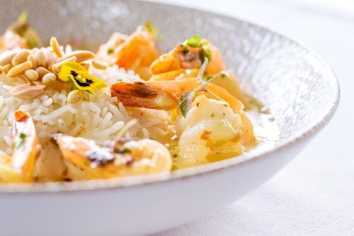 Creamy garlic prawns served in a white bowl. - Australian Stock Image