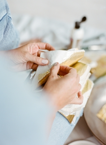 Creative painter working with gold leaves - Australian Stock Image