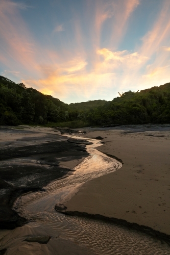 Creek flowing on Dudley beach at sunset - Australian Stock Image