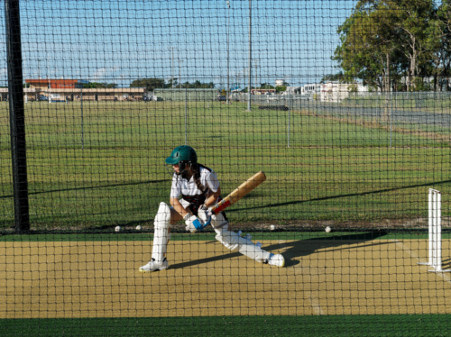 Cricket training and practice in the nets for left handed female cricket player - Australian Stock Image