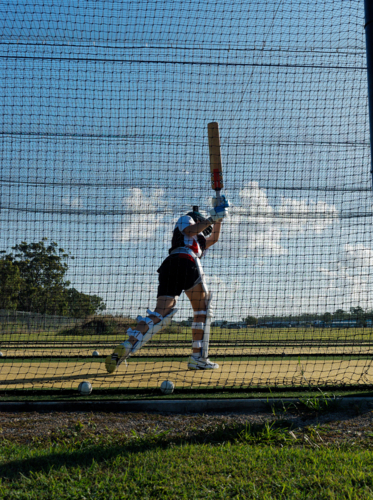 Cricket training and practice in the nets for left handed female cricket player - Australian Stock Image