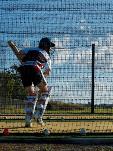 Cricket training and practice in the nets for left handed female cricket player - Australian Stock Image