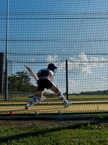 Cricket training and practice in the nets for young teen left handed female cricket player - Australian Stock Image