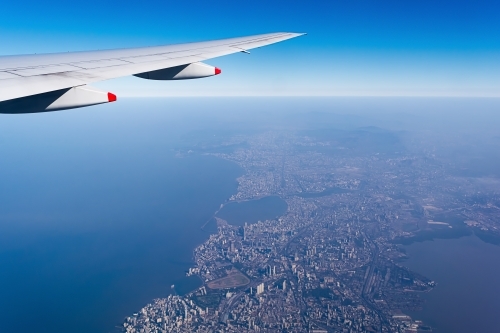 Cropped Image Of Aircraft Wing Over coastal city