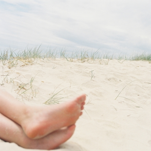 Cropped shot of bare feet on a sandy beach
