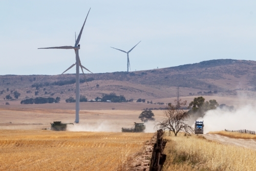 crops being harvested under wind turbines