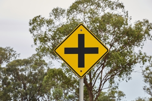 Crossroads sign on road with eucalyptus forest - Australian Stock Image