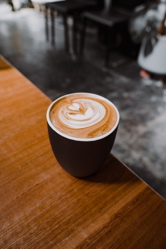 Cup of cafe coffee with latte art on a wooden table. - Australian Stock Image