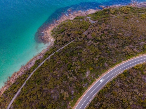 Curved road along coastline surrounded by bush scrub