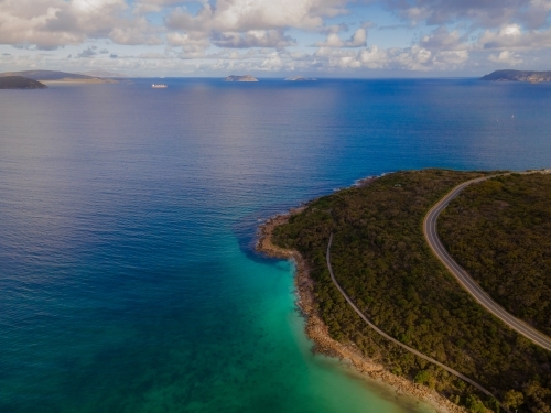 Curved road along coastline surrounded by bush scrub - Australian Stock Image