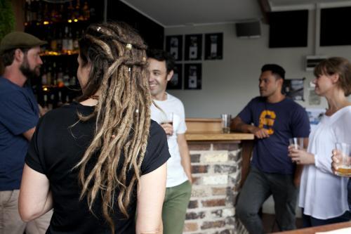 Customers standing having a drink at local pub - Australian Stock Image