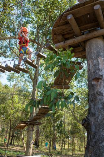 Cute 3 year old mixed race boy plays on an adventure ropes course - Australian Stock Image