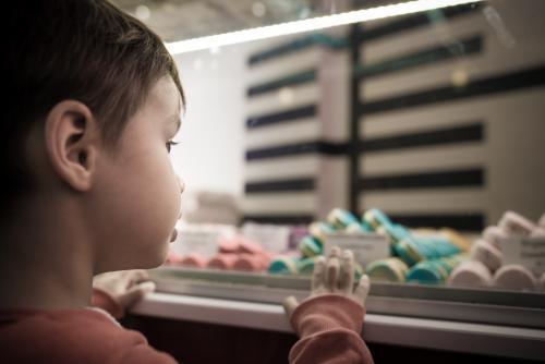Cute 4 year old mixed race boy chooses a macaron treat - Australian Stock Image