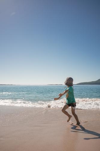 Cute 6 year old boy plays happily in the water on a Port Stephens beach