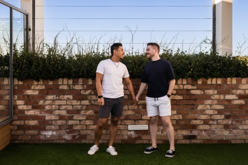 cute gay couple holding hands - Australian Stock Image