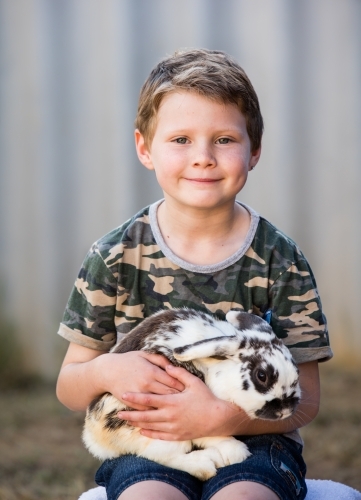 Cute young boy holding pet bunny