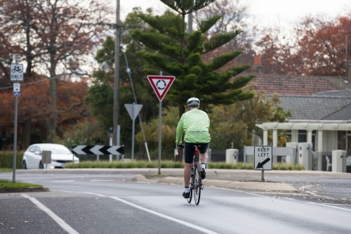 cyclist approaching a roundabout in the city - Australian Stock Image
