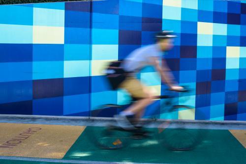 Cyclist blurred against blue tiled background - Australian Stock Image