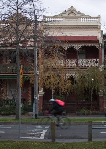 cyclist riding down a street in inner city suburbs - Australian Stock Image
