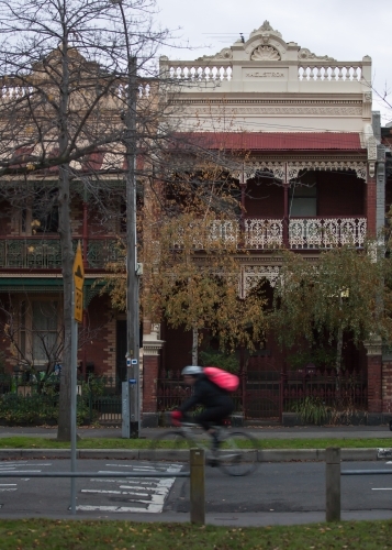 cyclist riding down a street in inner city suburbs