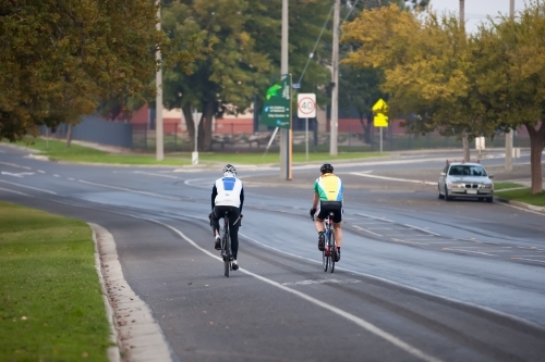 cyclists riding on a bike path in a city - Australian Stock Image