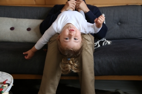 Dad with daughter upside down on couch