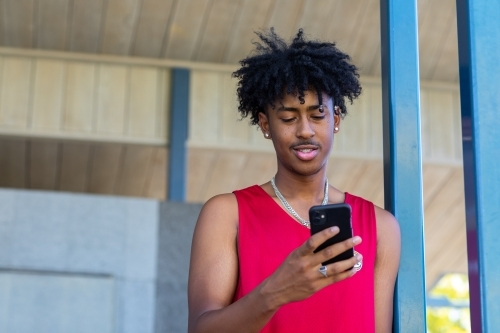 dark-haired teen boy with mobile phone - Australian Stock Image