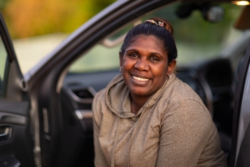 dark-skinned woman looking out of car passenger seat - Australian Stock Image
