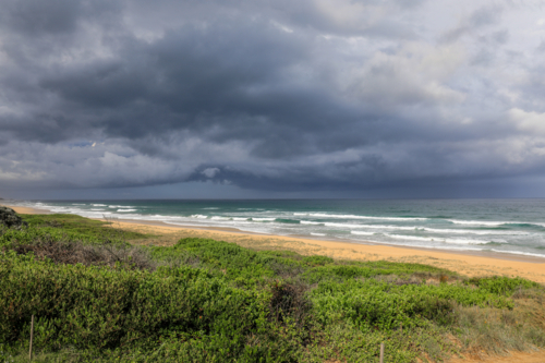 Dark stormy clouds forming over North Beach in Mylestom, NSW, Australia. Dramatic coastline - Australian Stock Image