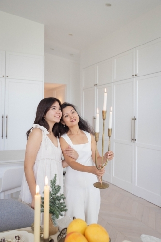 Daughter with mother holding candelabra - Australian Stock Image