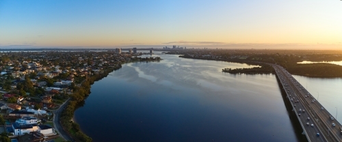 Dawn breaks over Perth's Canning River with the city skyline on the horizon