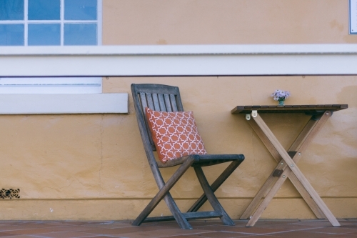 Deck chair and small table outside building