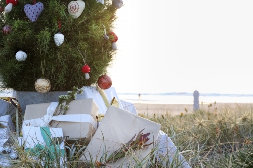 Decorated Christmas tree with presents and beach at sunrise